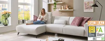 Frau sitzt auf gemütlichen weißem Sofa und entspannt.